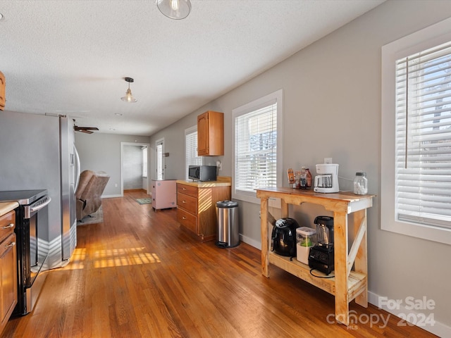 kitchen with appliances with stainless steel finishes, dark hardwood / wood-style flooring, and a textured ceiling