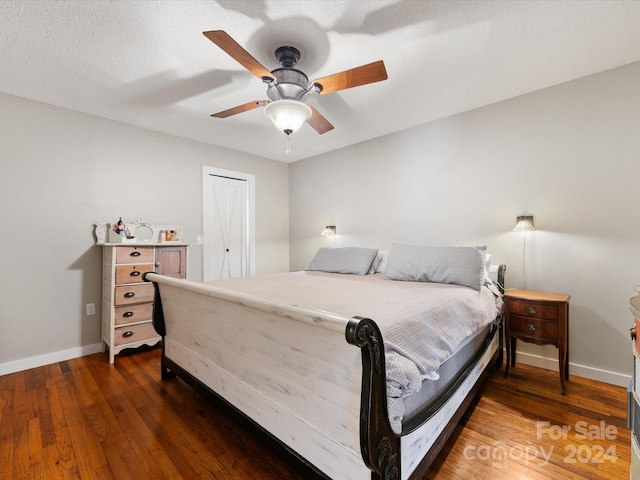 bedroom featuring a textured ceiling, a closet, ceiling fan, and dark wood-type flooring