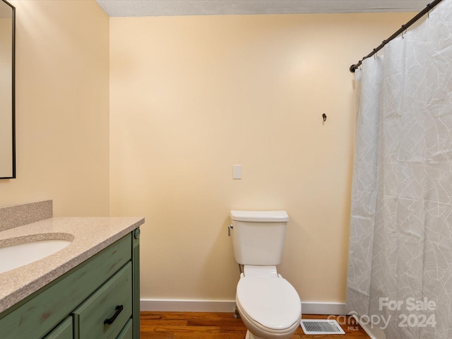 bathroom with vanity, wood-type flooring, and toilet