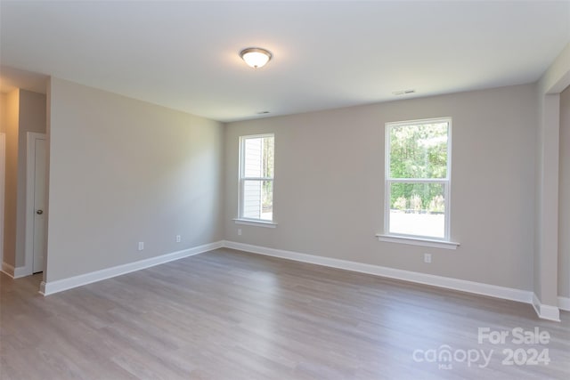 empty room with light hardwood / wood-style floors and a wealth of natural light