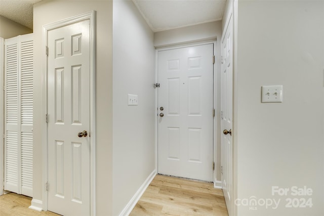 doorway with light hardwood / wood-style flooring and a textured ceiling