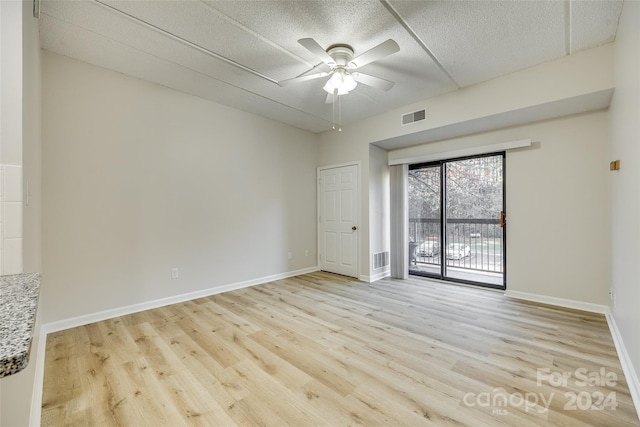 spare room featuring a textured ceiling, light hardwood / wood-style flooring, and ceiling fan