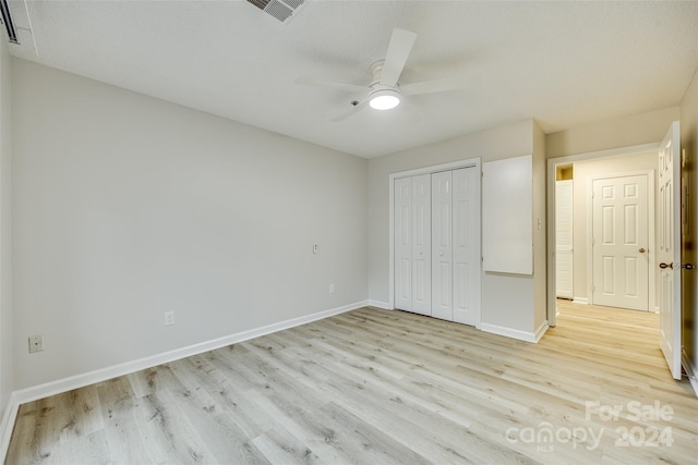 unfurnished bedroom featuring a textured ceiling, ceiling fan, light hardwood / wood-style flooring, and a closet