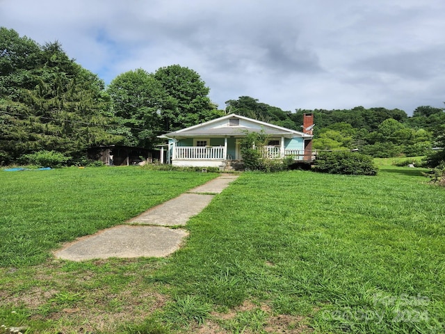 view of front of property featuring covered porch and a front lawn