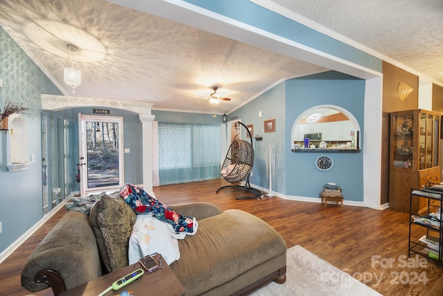 living room featuring ceiling fan, ornamental molding, a textured ceiling, and hardwood / wood-style flooring