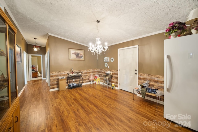 dining space with hardwood / wood-style floors, a notable chandelier, crown molding, and a textured ceiling