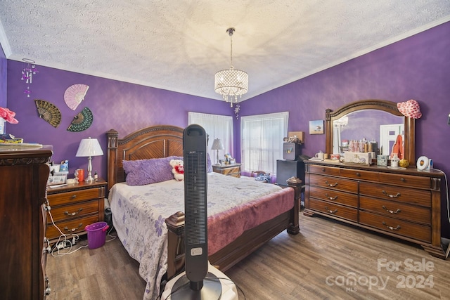 bedroom featuring hardwood / wood-style floors, a textured ceiling, and crown molding