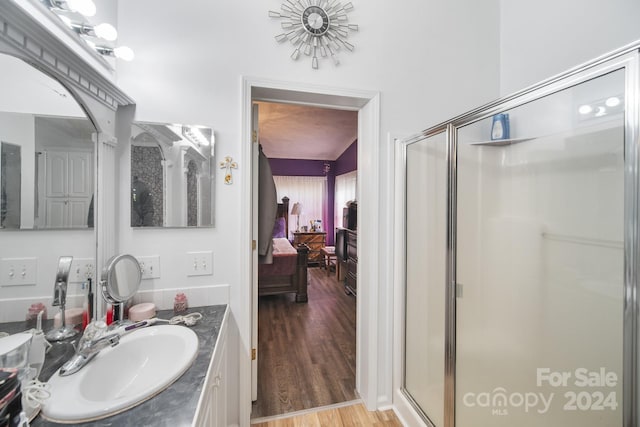 bathroom with vanity, wood-type flooring, and a shower with shower door