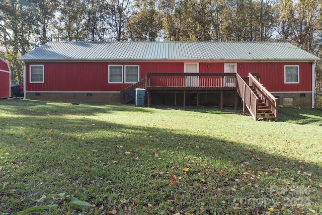 back of property with a yard and a wooden deck