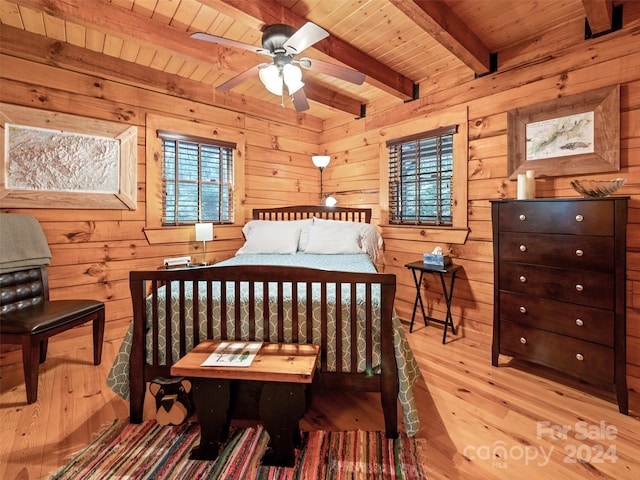 bedroom with beam ceiling, multiple windows, light hardwood / wood-style flooring, and wood ceiling