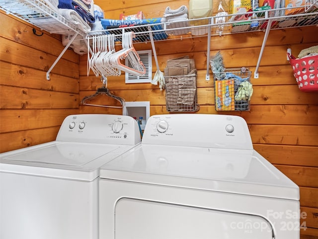 laundry room with wood walls and independent washer and dryer