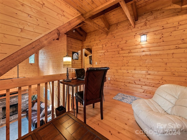 sitting room with vaulted ceiling with beams, wooden ceiling, light hardwood / wood-style floors, and wood walls