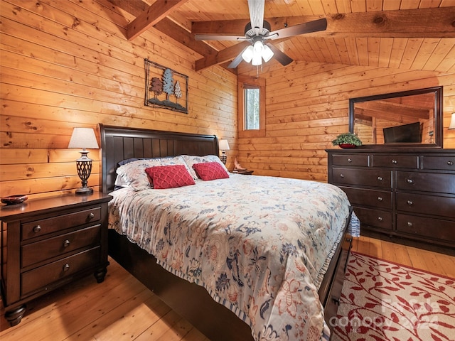 bedroom with ceiling fan, wooden ceiling, vaulted ceiling with beams, wood walls, and light wood-type flooring