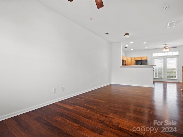 unfurnished living room with ceiling fan, dark wood-type flooring, and french doors