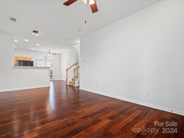 unfurnished living room featuring ceiling fan and dark hardwood / wood-style flooring