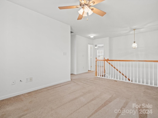 spare room featuring light colored carpet and ceiling fan