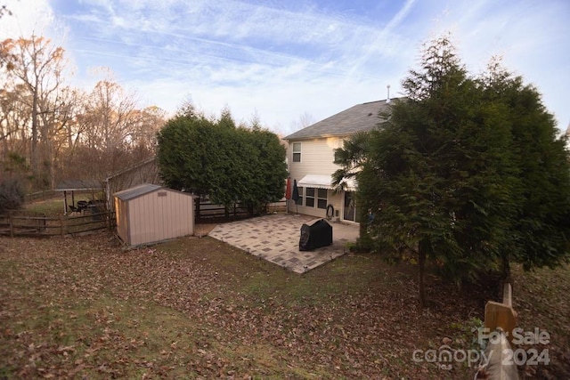 view of yard featuring a storage unit and a patio