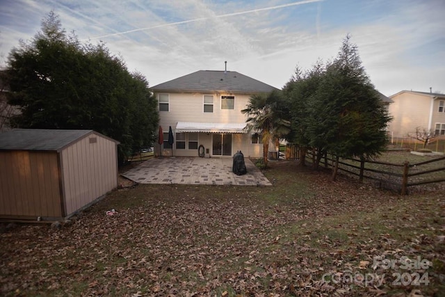 rear view of property featuring a patio area and a storage shed