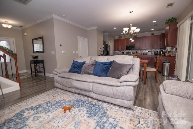 living room with ornamental molding, dark hardwood / wood-style floors, and a notable chandelier