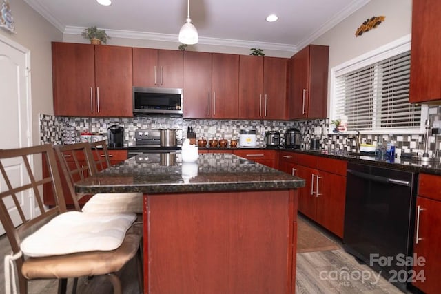 kitchen featuring a kitchen breakfast bar, stainless steel appliances, pendant lighting, wood-type flooring, and a center island