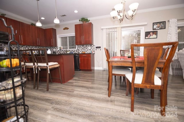 kitchen with an inviting chandelier, crown molding, wood-type flooring, decorative light fixtures, and decorative backsplash