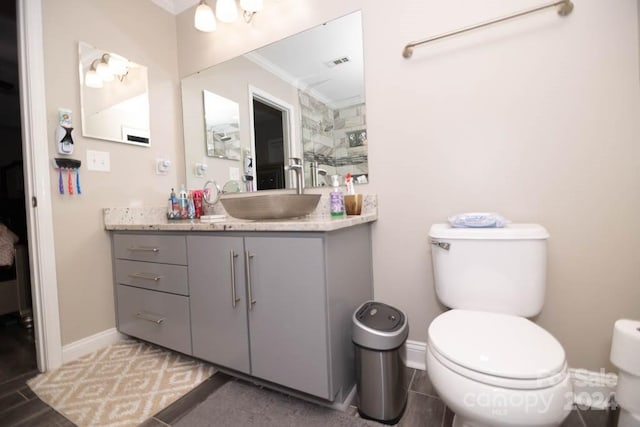 bathroom with toilet, vanity, and ornamental molding