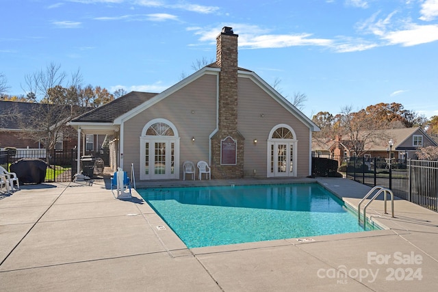 view of swimming pool featuring french doors and a patio