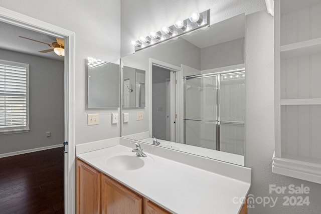 bathroom with hardwood / wood-style floors, vanity, ceiling fan, and a shower with shower door