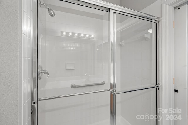 bathroom with a shower with door