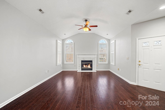 unfurnished living room featuring dark hardwood / wood-style flooring, ceiling fan, plenty of natural light, and lofted ceiling