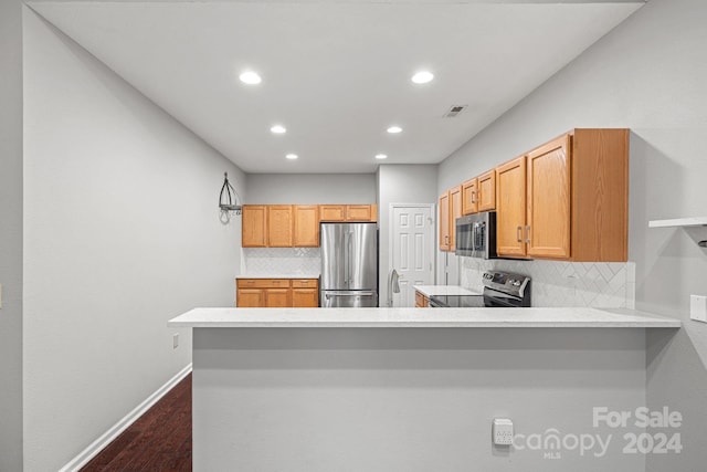 kitchen with kitchen peninsula, light brown cabinetry, dark hardwood / wood-style flooring, backsplash, and stainless steel appliances