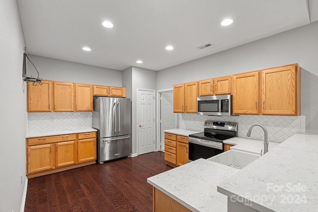 kitchen featuring dark hardwood / wood-style floors, sink, stainless steel appliances, and tasteful backsplash