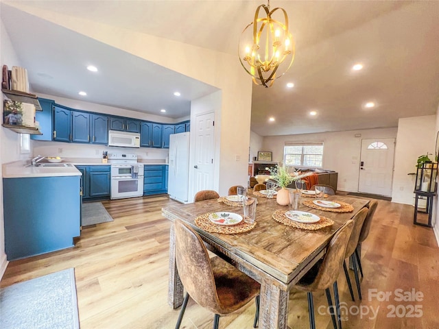 dining area featuring recessed lighting, light wood-style flooring, and a notable chandelier