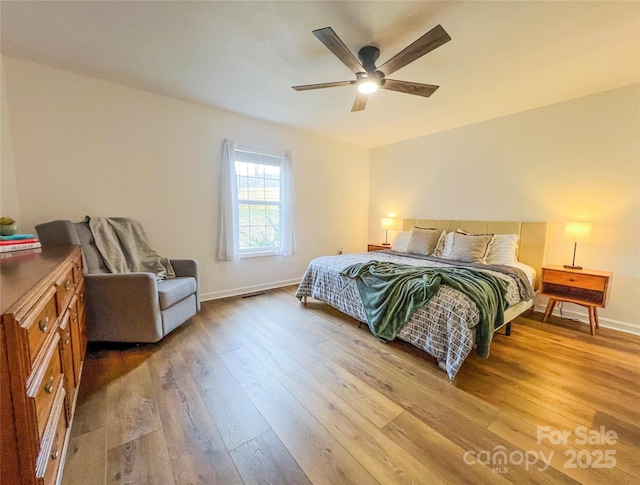 bedroom featuring light wood-style floors, a ceiling fan, and baseboards