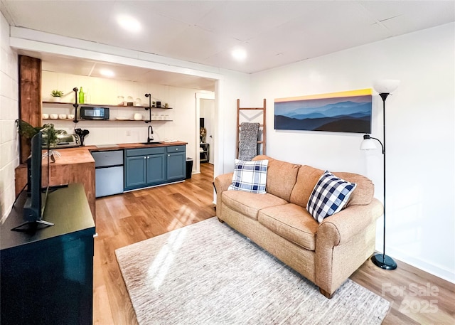 living area featuring light wood-style flooring and a toaster