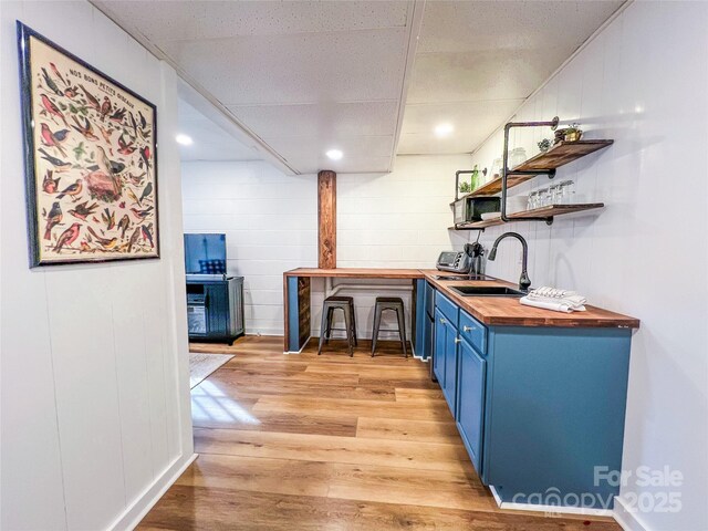 bar with a sink, light wood-style flooring, indoor wet bar, recessed lighting, and a toaster