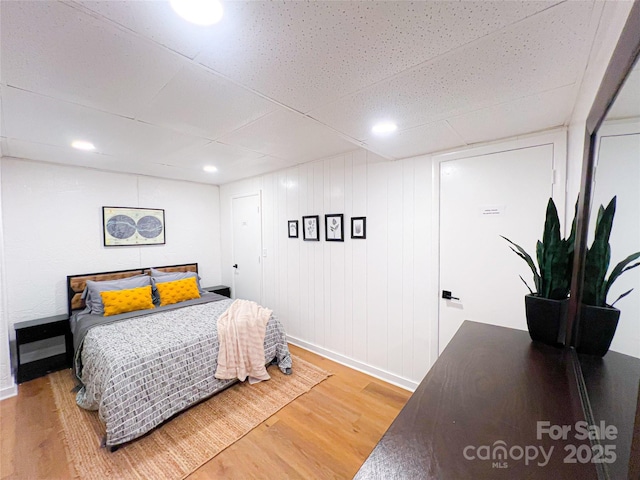 bedroom featuring light wood-type flooring, recessed lighting, and baseboards