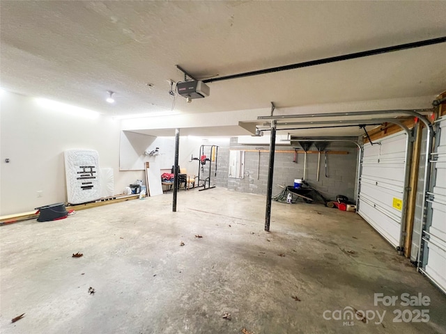 garage featuring a garage door opener and concrete block wall