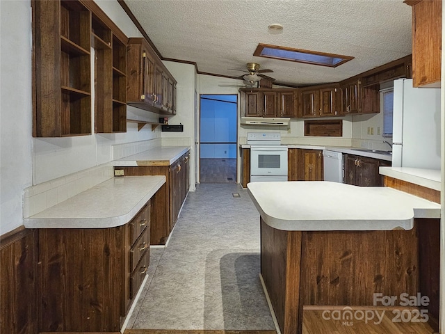 kitchen featuring sink, ceiling fan, kitchen peninsula, dark brown cabinets, and white appliances