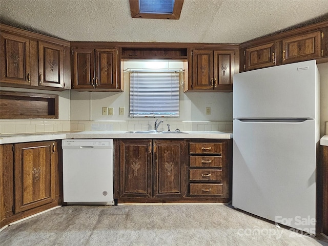 kitchen featuring white appliances, sink, dark brown cabinets, and a textured ceiling