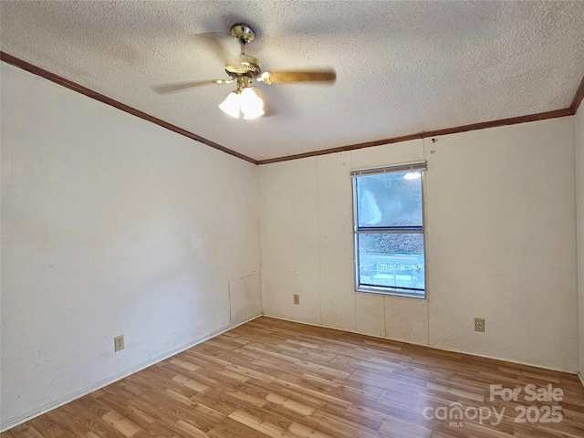 empty room with crown molding, ceiling fan, light hardwood / wood-style flooring, and a textured ceiling