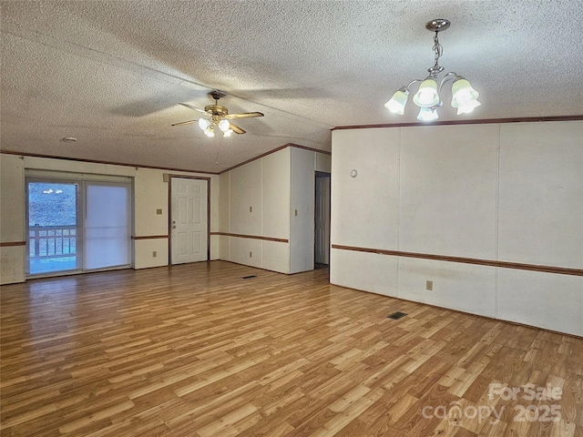 empty room featuring crown molding, ceiling fan with notable chandelier, a textured ceiling, and light wood-type flooring