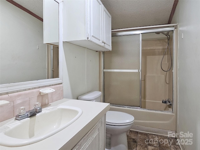 full bathroom featuring enclosed tub / shower combo, vanity, toilet, and a textured ceiling