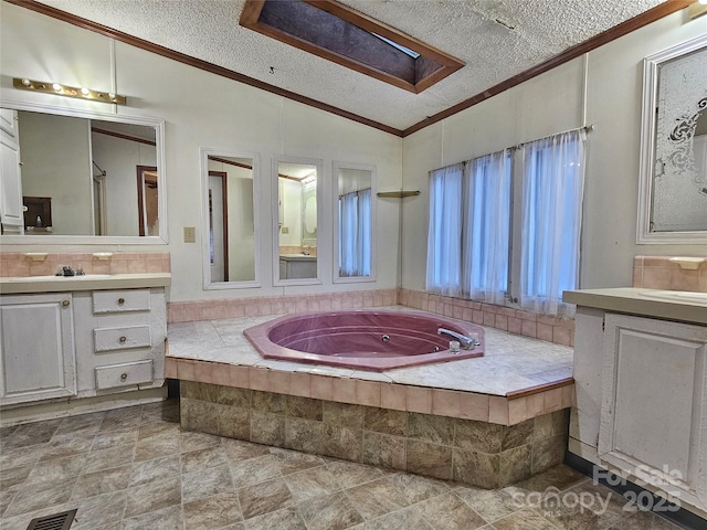 bathroom featuring vaulted ceiling, tiled bath, vanity, crown molding, and a textured ceiling