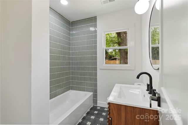 full bathroom featuring visible vents, bathtub / shower combination, vanity, and baseboards