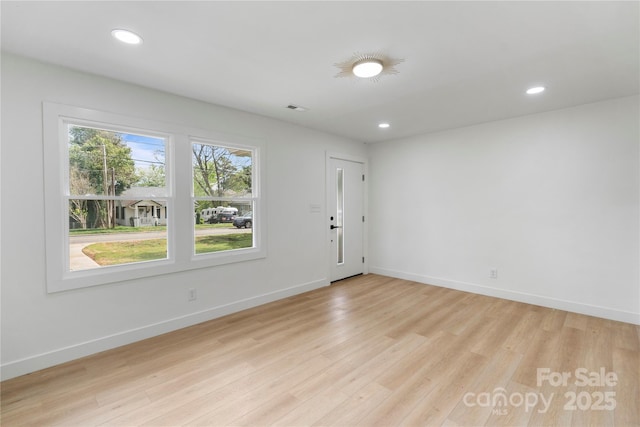 empty room with recessed lighting, light wood-style floors, baseboards, and visible vents