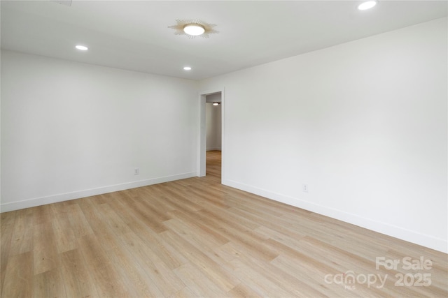spare room featuring light wood-style floors, baseboards, and recessed lighting