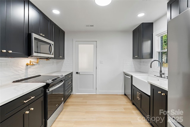 kitchen with visible vents, recessed lighting, a sink, stainless steel appliances, and light wood finished floors