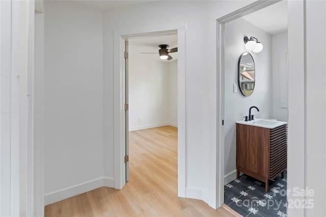 bathroom with vanity, ceiling fan, baseboards, and wood finished floors