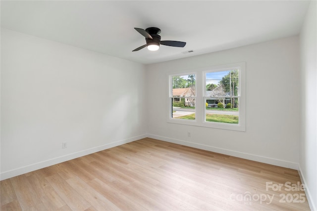 unfurnished room with ceiling fan, light wood finished floors, baseboards, and visible vents